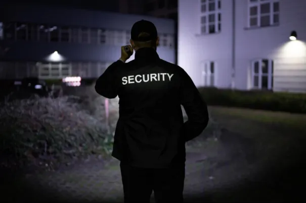 Night Patrol Techniques | Online Security Guard Training by Guard Training Security guard patrolling a property at night with flashlight, showcasing real-world applications of online security guard training from Guard Training.