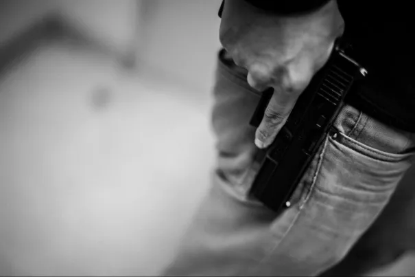 Firearm handling techniques covered in Guard Training’s online security training program Close-up of a person practicing firearm safety during online security guard training