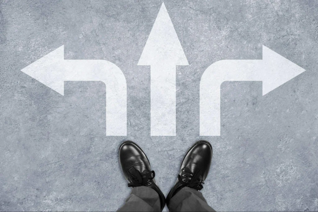 Person standing at a three-way directional arrow, symbolizing career path decisions.