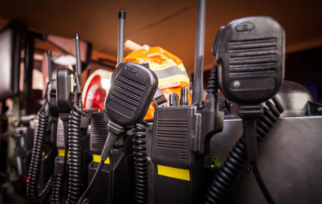 Close-up of multiple security radios and communication devices in a charging station.