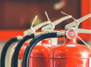 Close-up of red fire extinguishers used in online security guard training courses from Guard Training