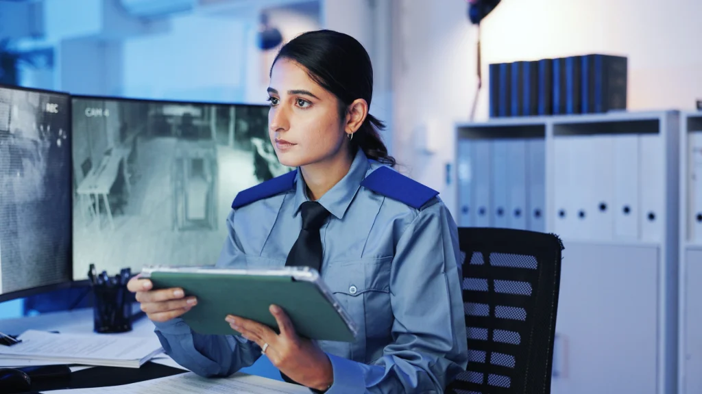Female security officer reviewing surveillance footage during security guard orientation.