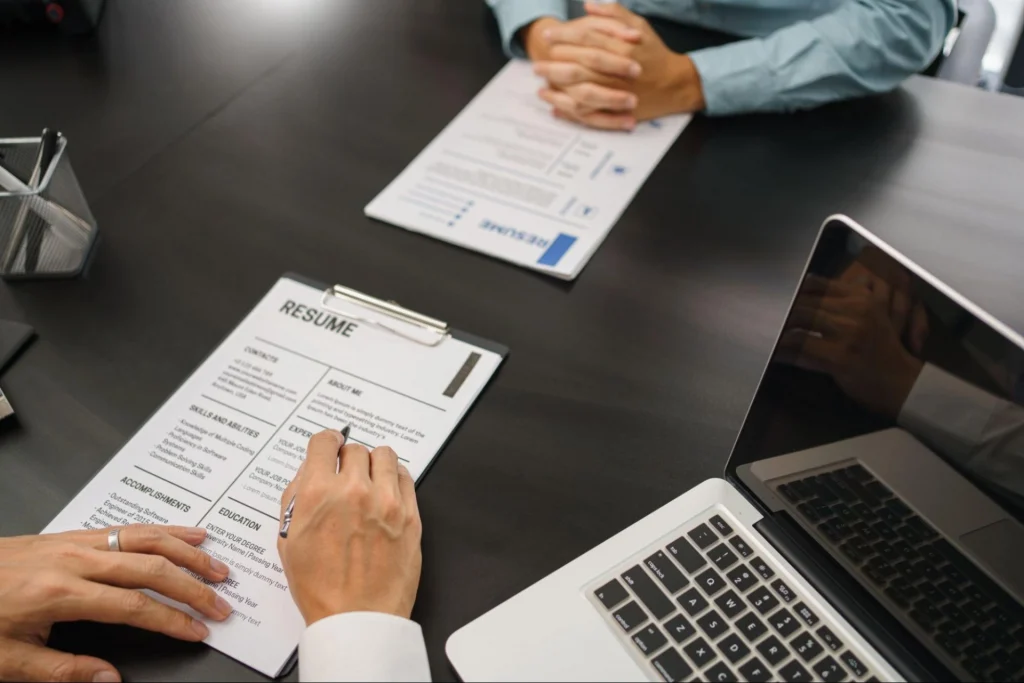 Employer reviewing a resume during a security guard job interview, highlighting career outcomes from Guard Training.