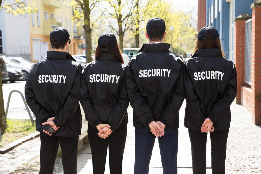 Group of security guards in uniform standing in a row, representing professional team training – Guard Training online security training.