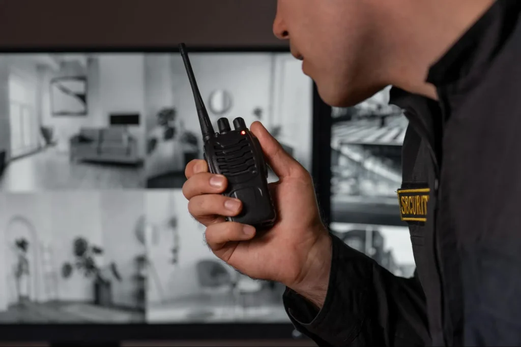 Security guard using radio communication while monitoring surveillance systems in Guard Training course